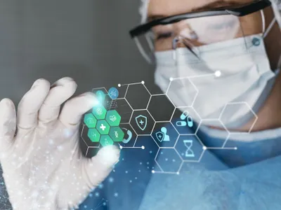 Doctor cercetător cu ochelari de protecţie, lucrând cu inteligenţă artificială - Foto: Freepik/CC0