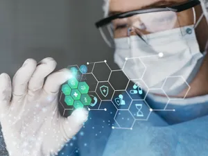 Doctor cercetător cu ochelari de protecţie, lucrând cu inteligenţă artificială - Foto: Freepik/CC0