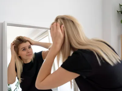 O femeie își verifică părul - Foto: Freepik (rol ilustrativ)