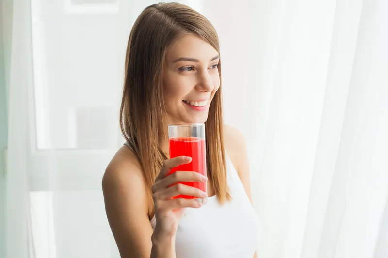 Femeie frumoasă care bea un pahar cu suc - Foto: Freepik (imagine cu rol ilustrativ)