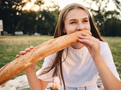 Tânără gustând pâine - Foto: Freepik