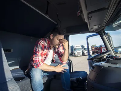 Camionagiu obosit, pregătindu-se să se culce în cabina camionului său - Foto: Magnific.com/aleksandarlittlewolf