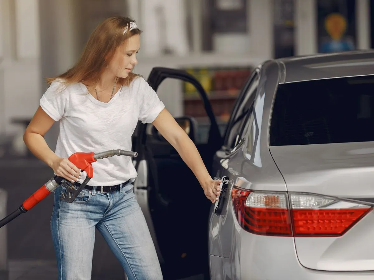 Tânără femeie alimentând la pompa de benzină - Foto: Freepik/prostooleh