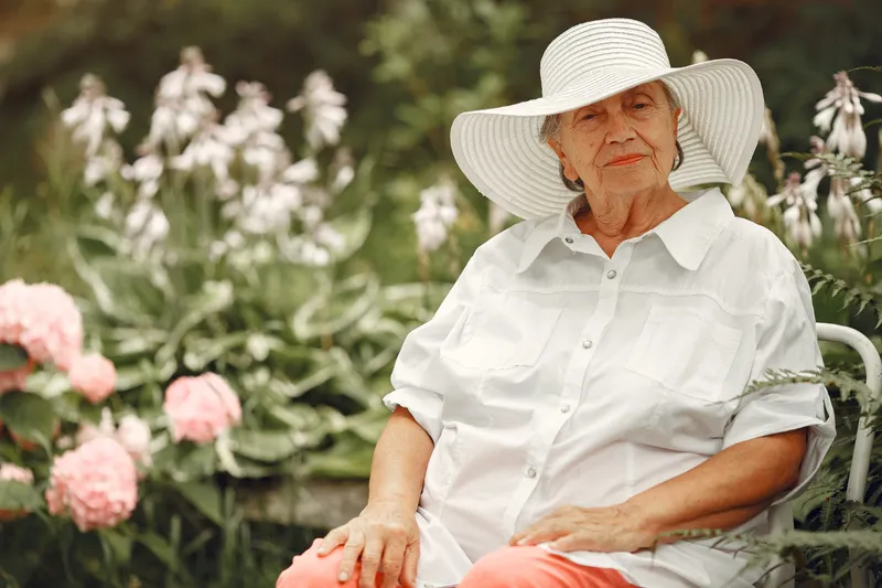 Pensionară &icirc;mbrăcată cu o bluză albă, lejeră &icirc;n grădină - Foto: Magnific.com (Imagine cu rol ilustrativ)