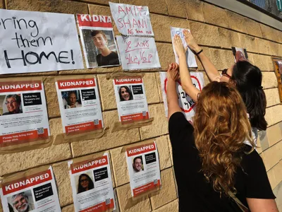 Family members of Israeli hostages kidnapped by Hamas stick their pictures on a wall in Tel Aviv Photo: profimediaimages.ro