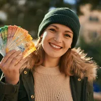 Fată cu un evantai de bancnote euro - Foto: Freepik/krakenimages.com