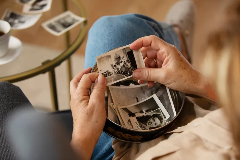 O femeie care ține în mână o fotografie veche cu un strămoș decedat - Foto: Freepik