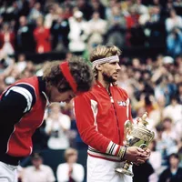 Björn Borg ținând în brațe cupa de argint acordată învingătorului de la Wimbledon. Lângă el, John McEnroe, marele învins