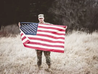 Soldat american ținând steagul american - Foto: Magnific.com (Imagine cu rol ilustrativ)