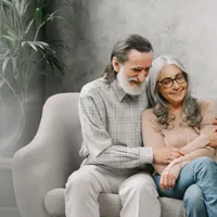 Cuplu fericit de seniori stând pe canapea şi vorbind - Foto: Freepik/prostooleh