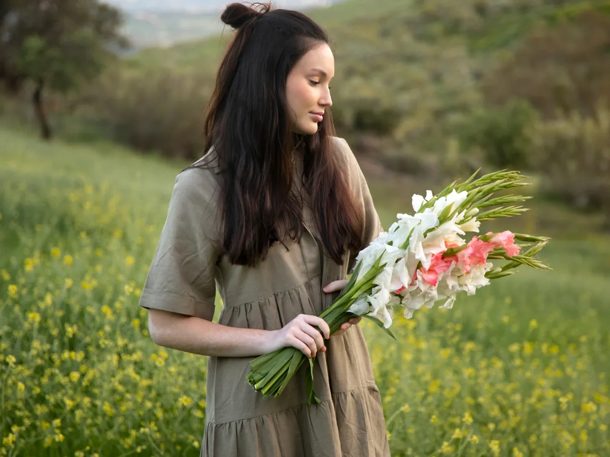 Persoană cu gladiole - Foto: Magnific.com (Imagine cu rol ilustrativ)