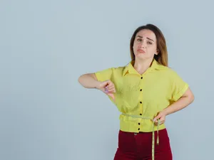 Femeie tristă care vrea să slăbească și se măsoară în talie - Foto: Freepik