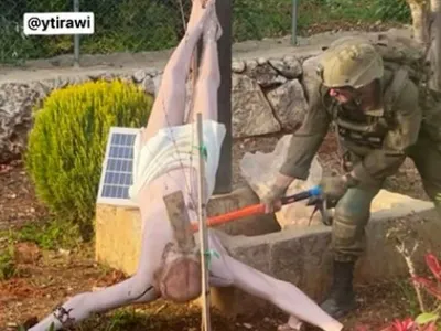 Un soldat israelian lovește cu un ciocan o statuie a lui Iisus din sudul Libanului. Armata confirmă autenticitatea fotografiei
