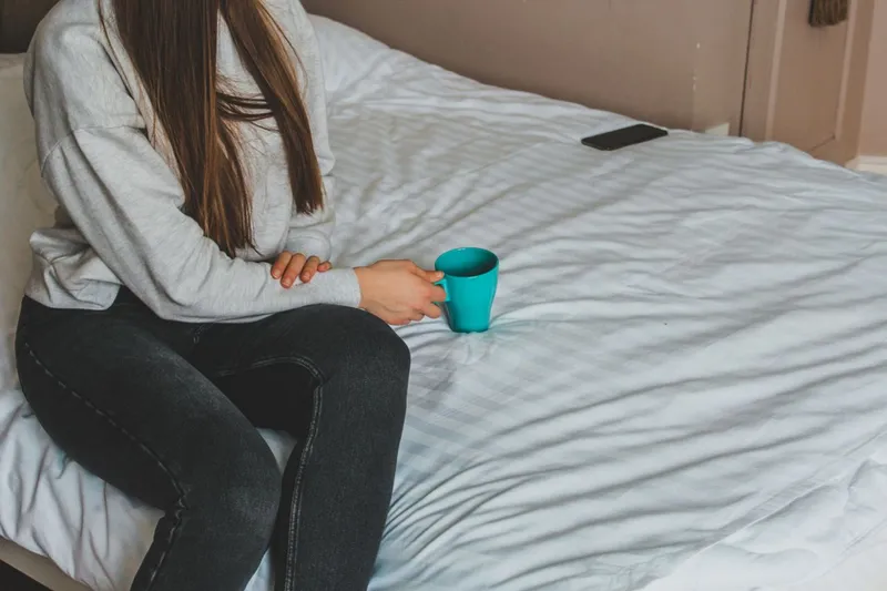 Femeie care stă pe pat - Foto: Pexels.com (Imagine cu rol ilustrativ)