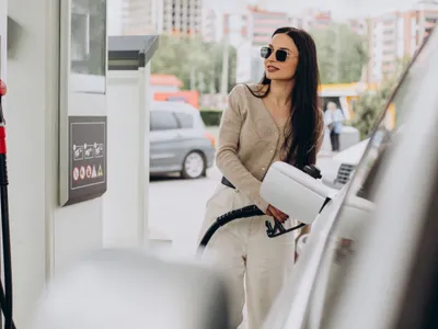 Tânără femeie alimentând la pompa de benzină - Foto: Freepik/senivpetro