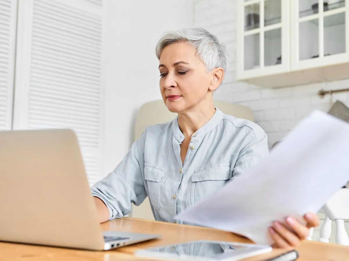 Pensionară făcând calcule - Foto: Freepik