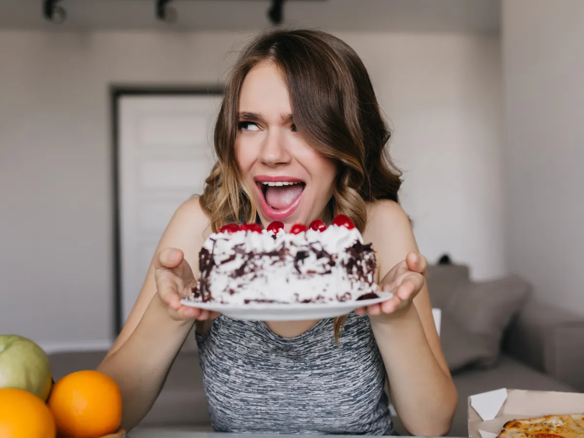 O femeie mănâncă o prăjitură - Foto: Preepik