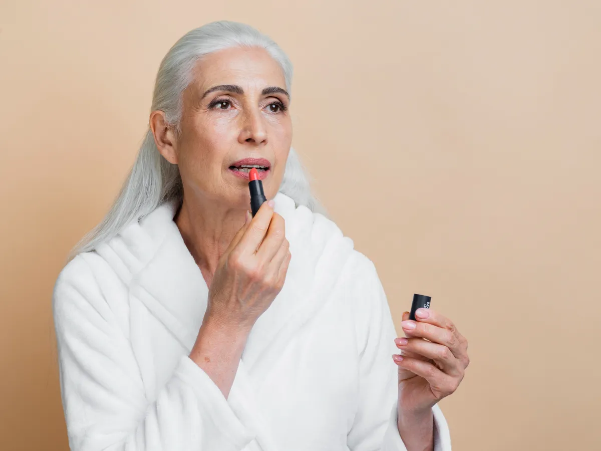 Femeie care dă cu ruj - Foto: Magnific.com (Imagine cu rol ilustrativ)