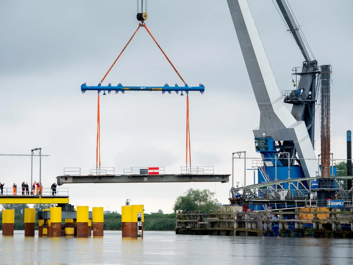 O secțiune avariată a podului feroviar peste râul Hunte , recuperată cu ajutorul unei macarale - Foto: Profimedia Images