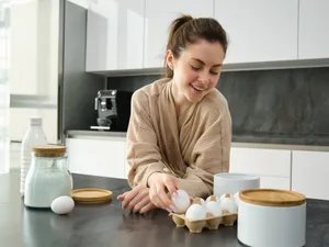 Femeie care are pe masă o cutie de ouă - Foto: Freepik (imagine cu rol ilustrativ)
