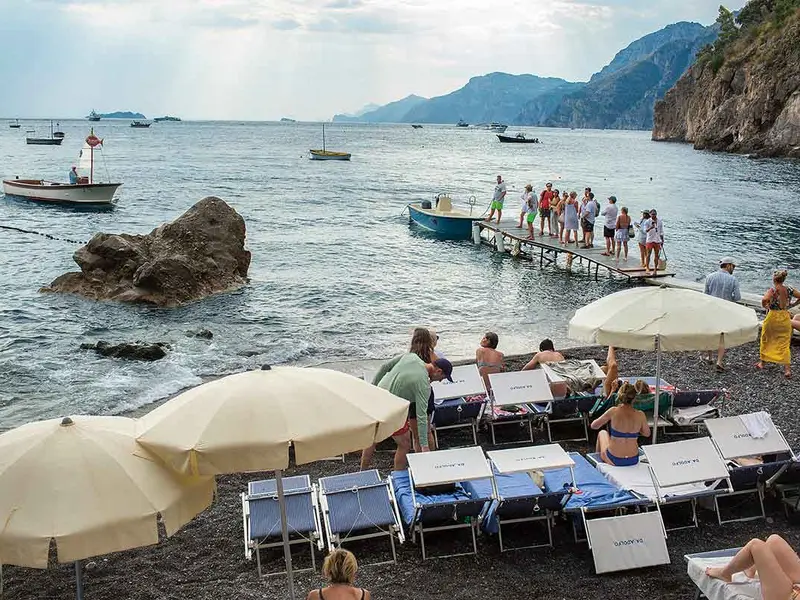 Oameni pe plaja Da Adolfo, unul dintre cele mai renumite restaurante de pe Coasta Amalfitană, în Positano - Foto: Mugur Vărzariu