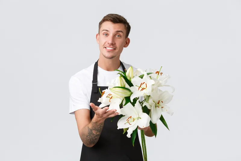Bărbat cu un buchet de crini - Foto: Magnific.com (Imagine cu rol ilustrativ)