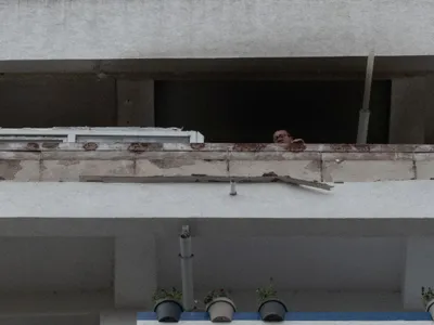 Un locatar se uită în jos, de la balcon, din Blocul Stirex, din centrul Galaţiului, lovit de o dronă rusească - Foto: INQUAM PHOTOS (Imagine cu caracter ilustrativ)