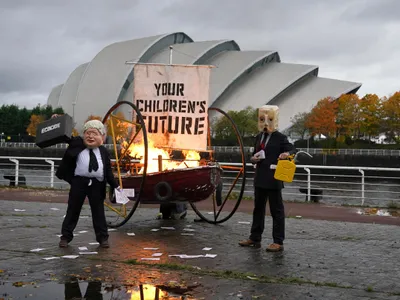 Conferinţa ONU pentru climă: un protestatar deghizat în Boris Johnson a incendiat o barcă. / Foto: thenational.scot