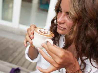 O femeie savurează o cafea cu lapte - Foto: freepik (rol ilustrativ)