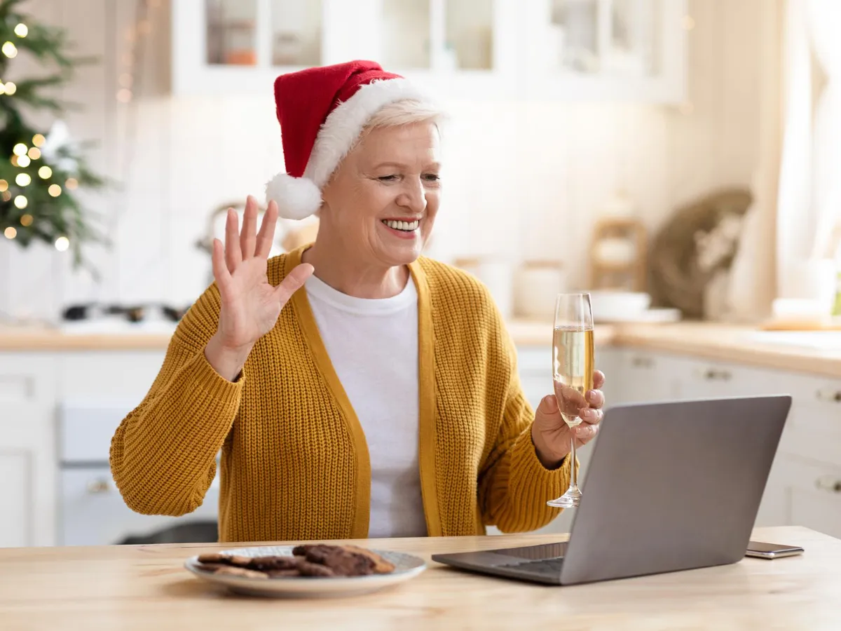 Pensionară care bea un pahar de șampanie și vorbește cu prietenii online - Foto: Freepik (Imagine cu rol ilustrativ)