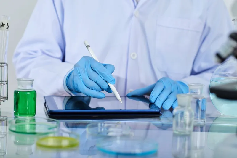 Laborant efectu&acirc;nd prelevări de probe &icirc;n secţia de cercetare - Foto: Magnific.com/pressfoto