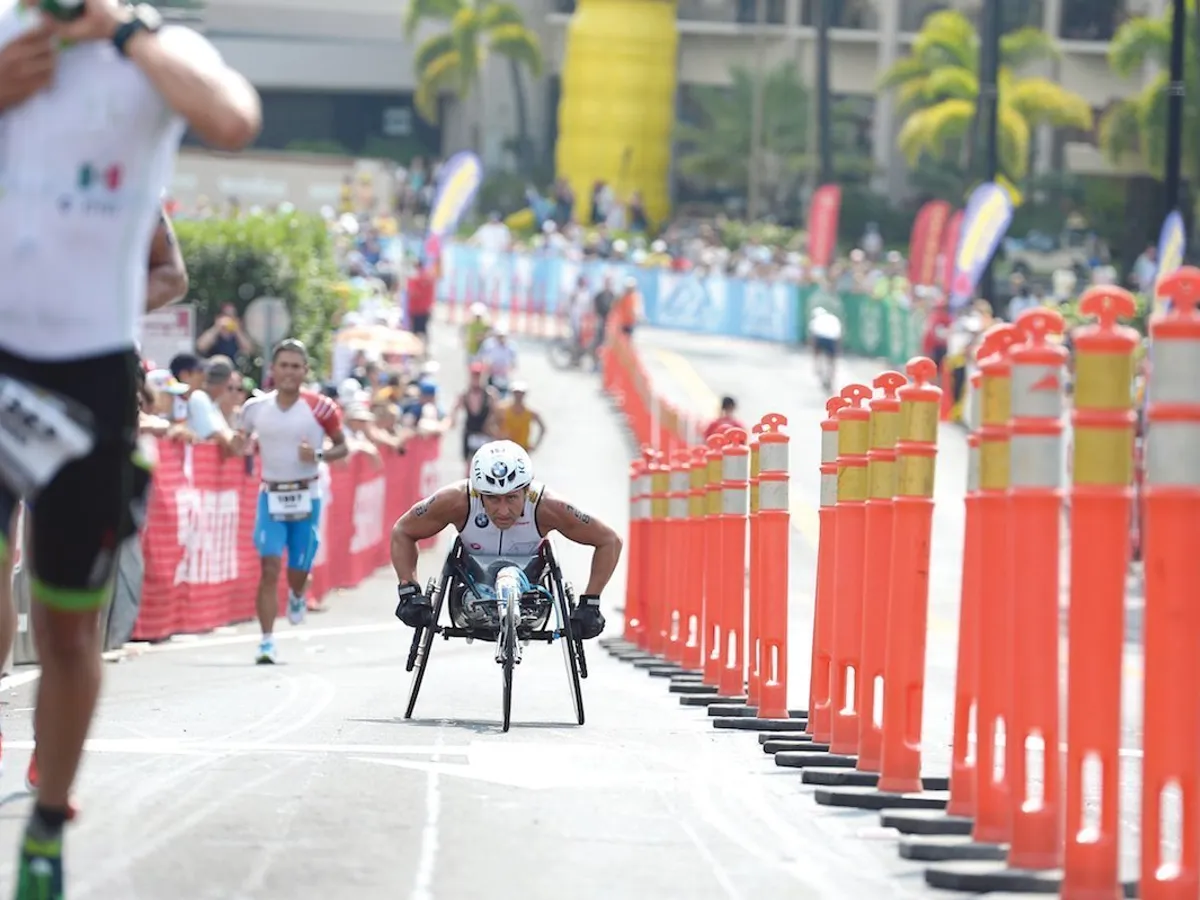 La triatlon, atletul fără picioare folosește un scaun cu rotile olimpic în proba de alergare ...