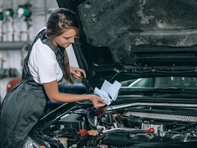 O șoferiță verifică uleiul de motor - Foto: magnific.com (Imagine cu rol ilustrativ)