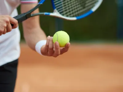 O persoană ține o minge de tenis în mână - Foto: Freepik (rol ilustrativ)