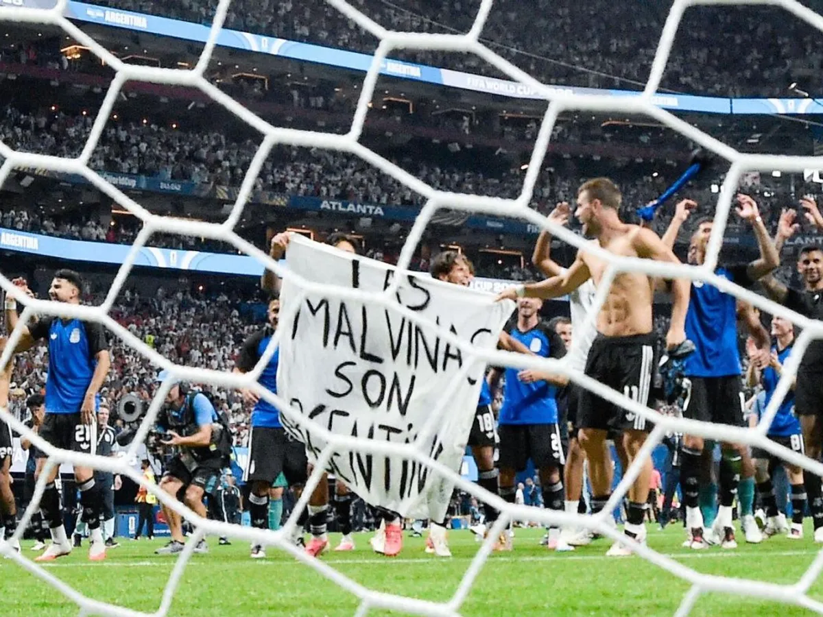 Jucătorii naţionalei Argentinei, pe teren, după un meci de la Cupa Mondială, cu bannerul "Malvinele sunt Argentina" - Foto: Profimedia Images