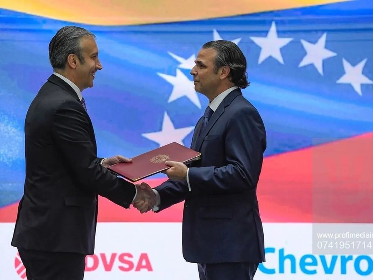Ministrul petrolului din Venezuela, Tareck El Aissami, (stânga), dă mâna cu președintele Chevron din Venezuela, Javier La Rosa, în timpul unei ceremonii de semnare a acordului, la Caracas - Foto: Profimedia Images - Foto: Profimedia Images