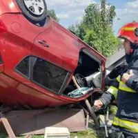 Mașina "s-a înfipt" cu roțile în sus în gardul unei case - Foto: ISU Giurgiu