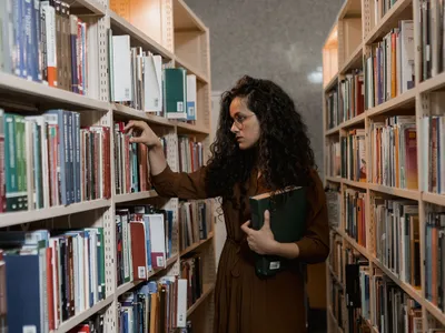 Femeie într-o bibliotecă publică - Foto: Pexels (cu rol ilustrativ)