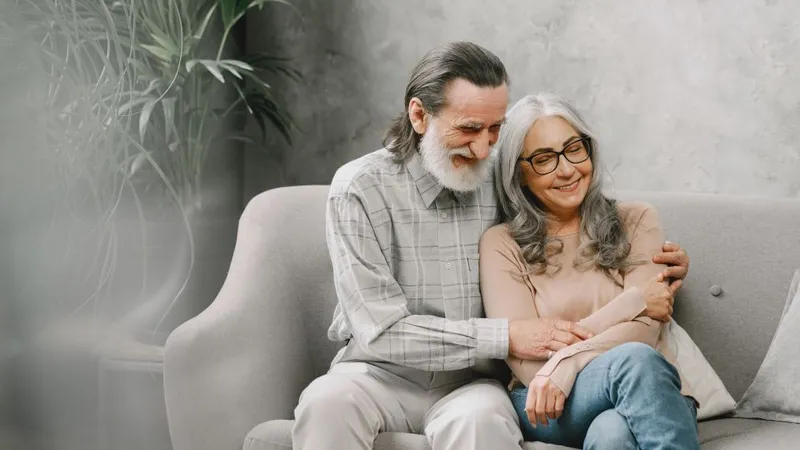Cuplu fericit de seniori stând pe canapea şi vorbind - Foto: Freepik/prostooleh