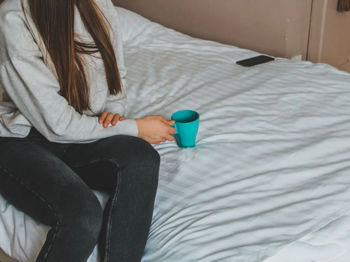 Femeie care stă pe pat - Foto: Pexels.com (Imagine cu rol ilustrativ)