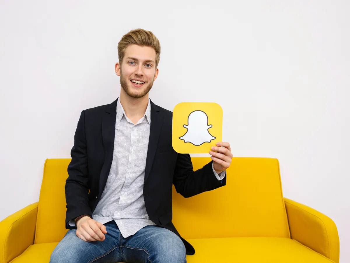 Bărbat care ține o poză cu aplicația Snapchat - Foto: Freepik (rol ilustrativ)