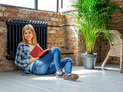Femeie lângă calorifer - Foto: Freepik (Imagine cu rol ilustrativ)