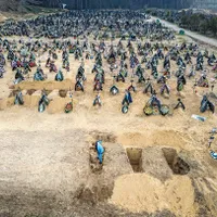 PĂMÂNT SFINȚIT Un gropar se pregătește pentru o înmormântare în masă, adăugând la rândurile de morminte din cimitir oameni uciși în timpul ocupației ruse a zonei