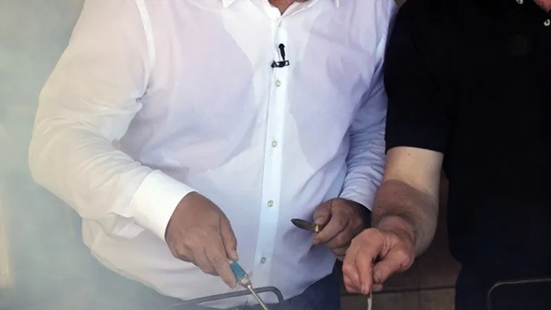 Liviu Dragnea, pregătind friptura în cămașă albă și cu lavaliera de la microfon deja montată Foto: Facebook