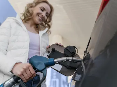 Femeie făcând plinul, la o pompă de carburant - Foto: Magnific.com/magnific