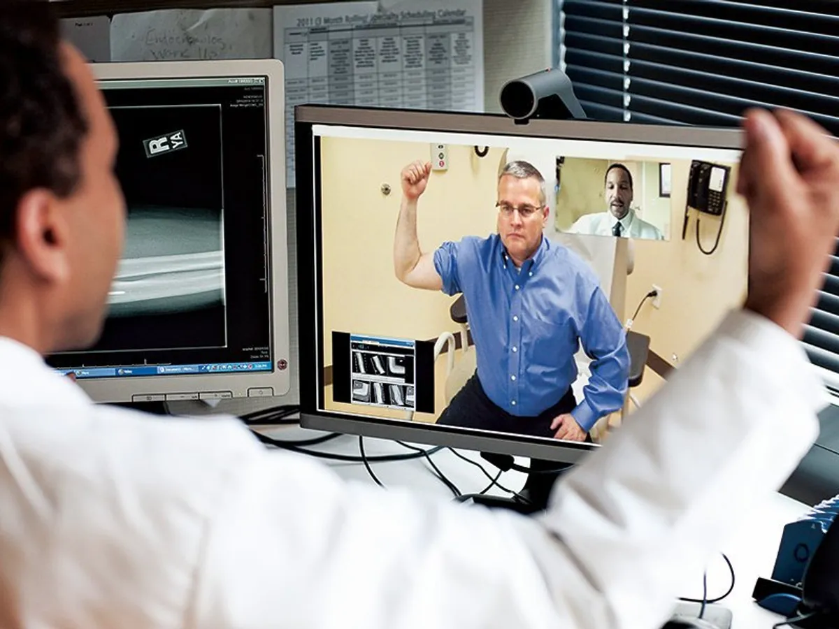 Un medic de îngrijire primară și un medic ortoped consultă un pacient prin intermediul sistemului video de la centrul medical Kaiser Permanente’ Capital Hill