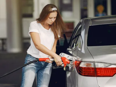Femeie făcând plinul la pompă - Foto: Freepik/prostooleh