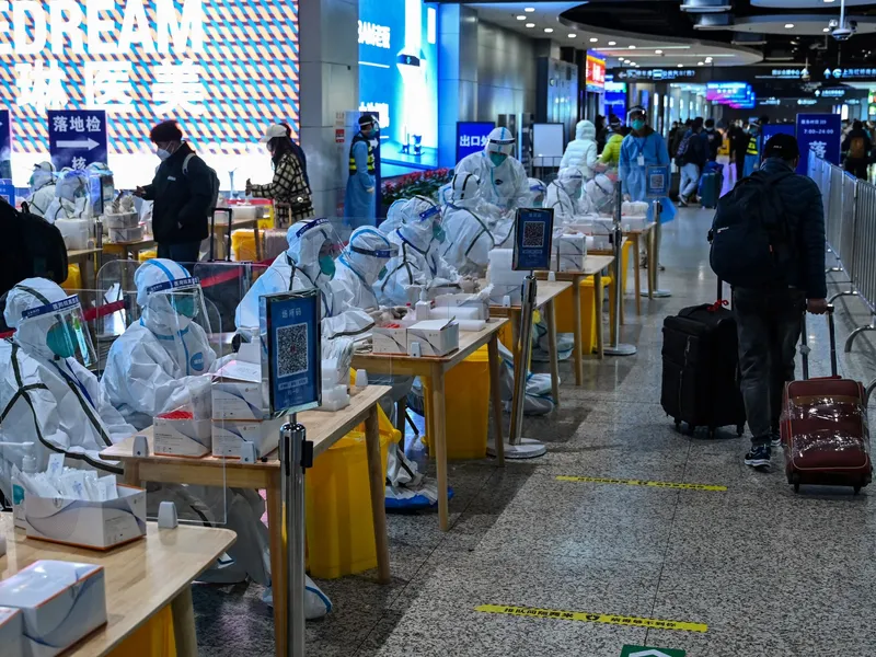 Lucrători din domeniul sănătății așteaptă să testeze pasagerii pentru Covid-19 la sosirea în Shanghai/Foto: Profimedia Images