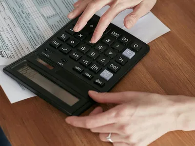 Femeie făcând calcule - Foto: Pexels/Mikhail Nilov