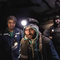 George Ștefoi (stânga), Florin Hașu (mijloc) și Marius Hiciu, așteptând cușca pentru a ieși din subteran la sfârșitul turei lor în mina Vulcan. Brigada Hașu lucrează la 276 m deasupra nivelului mării și mai mult de 350 m sub pământ